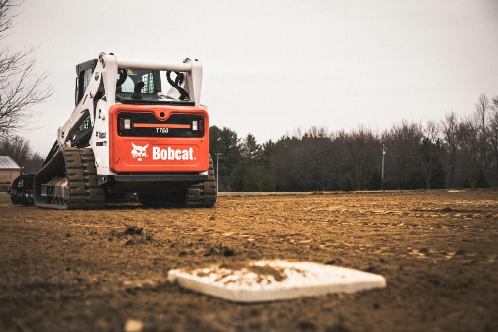 pexels-photo-25559744-25559744 A skid loader working on maintaining a baseball field under construction.